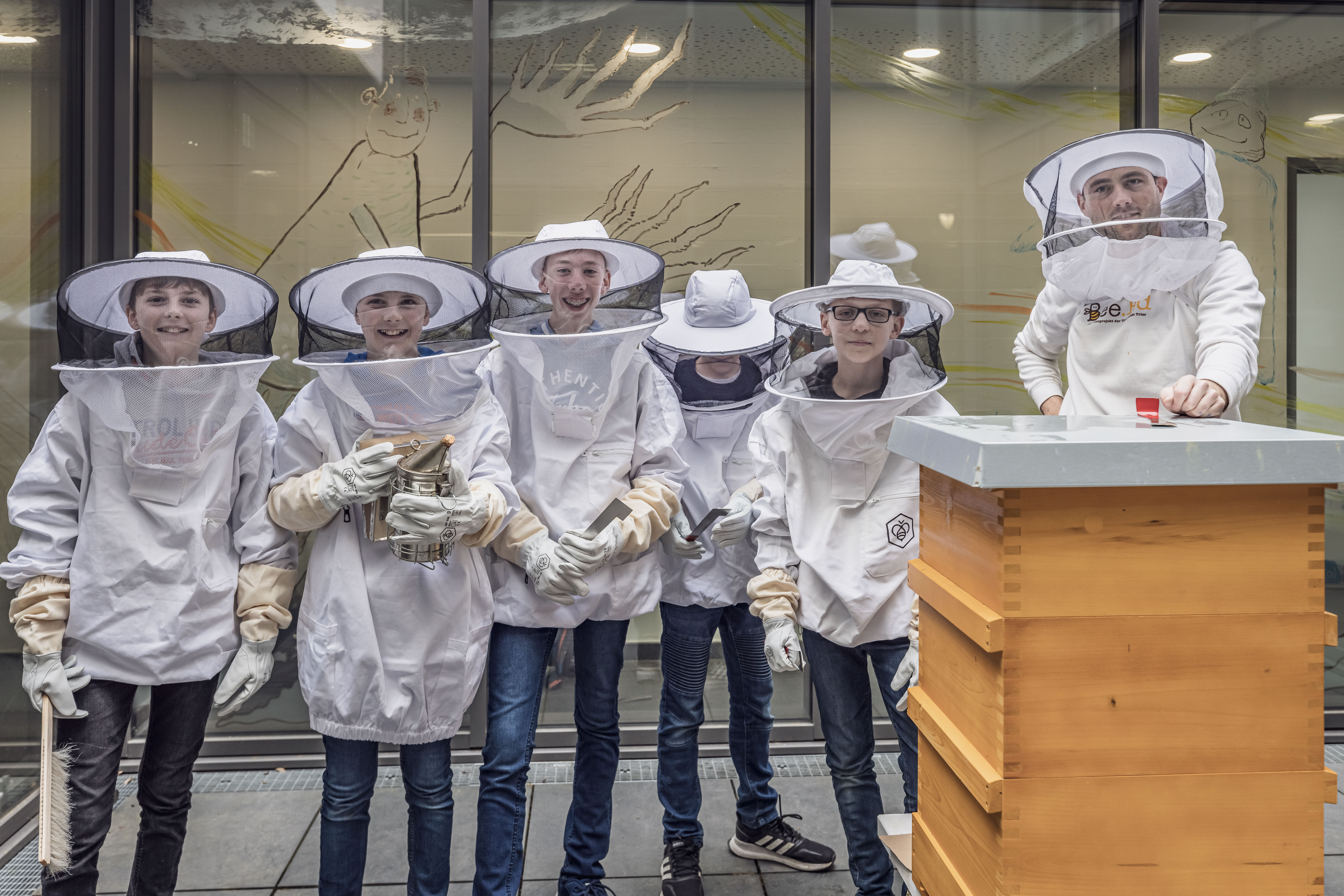 Einige Schüler posieren vor dem Schulgarten des Max-Planck-Gymnasiums
